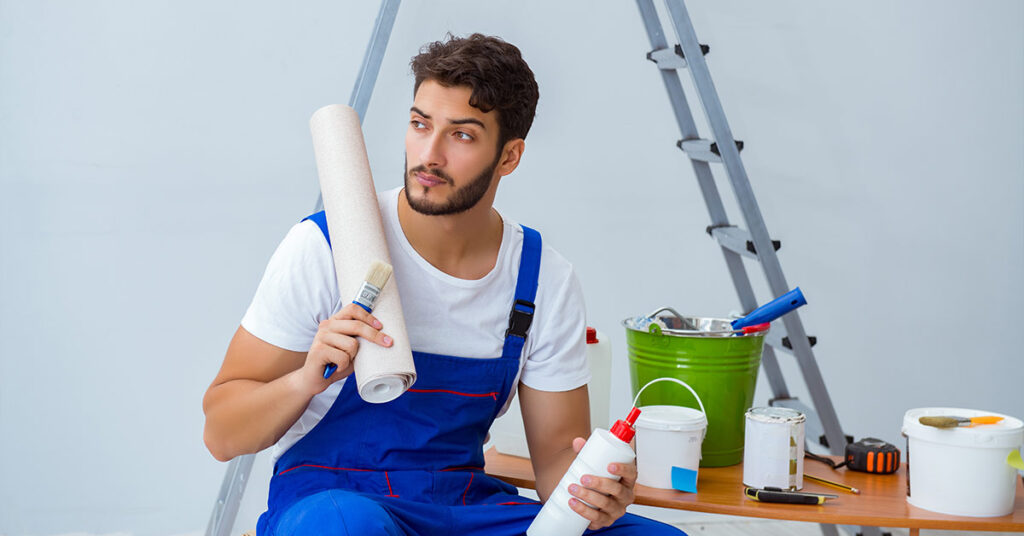 Reparateur bei Renovierungsarbeiten im Haus mit Papiertapete