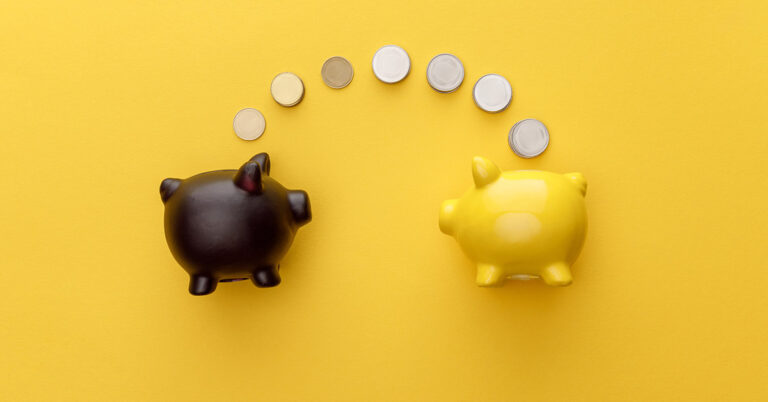 Ein gelbes und ein schwarzes Sparschwein, die Münzen miteinander tauschen. Ein Bild, dass auf Sparen und Immobilienfinanzierung hinweist