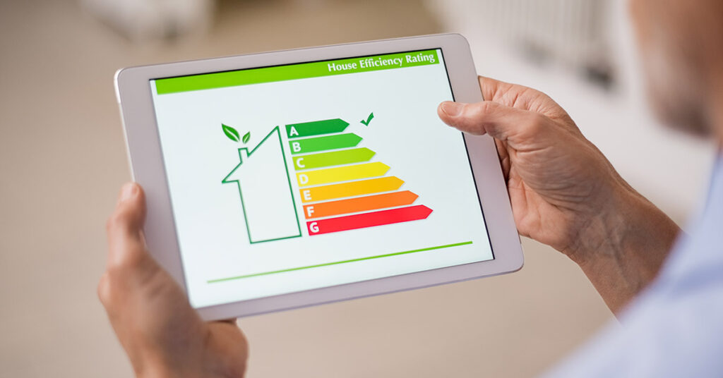 Ein Mann schaut auf ein Tablet, das die Energiebilanz seines Hauses anzeigt | Energieausweis