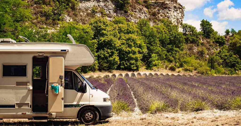 Ein Wohnmobil auf einem Feld vor einem Felsen in Südeuropa | Immobilienverrentung