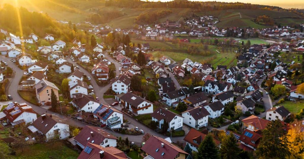 die Draufsicht auf ein Meer von deutschen Einfamilienhäusern, welche den Immobilienmarkt symbolisieren sollen