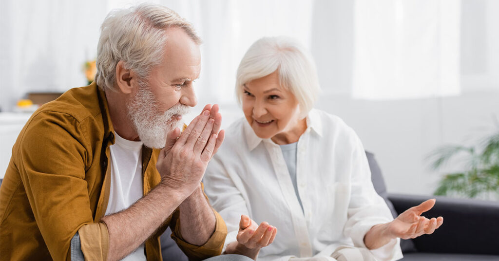 Ein älteres Paar sitzt zusammen und unterhält sich - Wohnwünsche im Alter