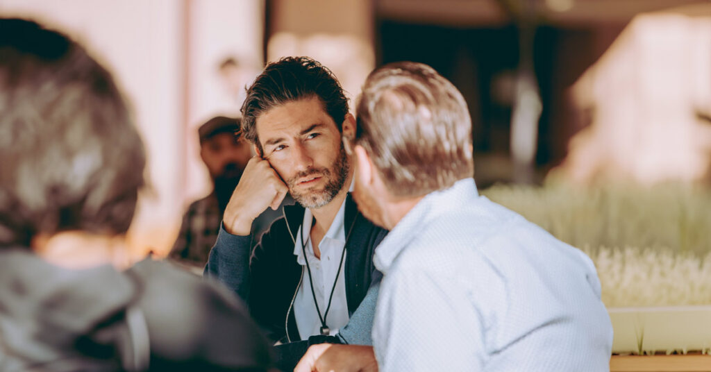 Zwei Männer im Gespräch in einem Café oder öffentlichen Raum – Symbolbild für Beratung, Zuhören, Kommunikation oder Coaching | Immobilienkauf